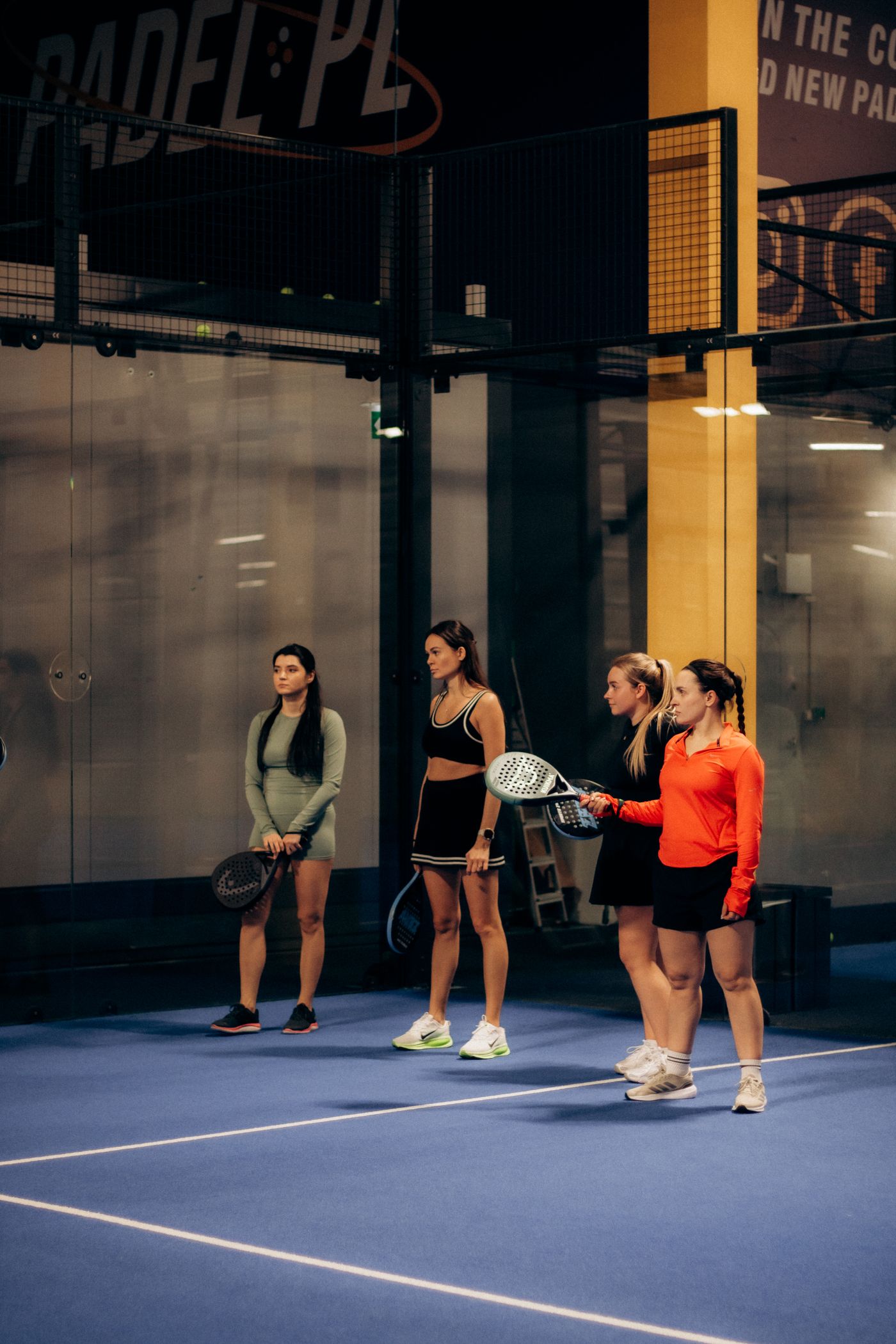 Quadra de padel coberta, com aula em andamento